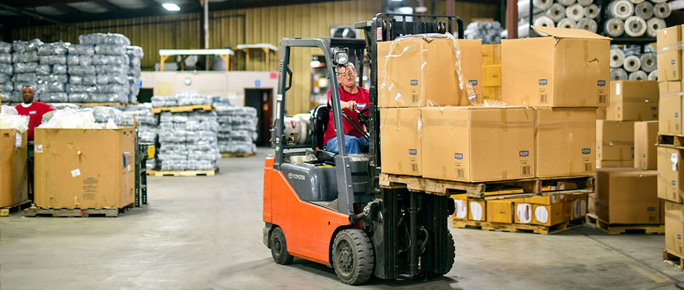 Forklift driver moving boxes wide