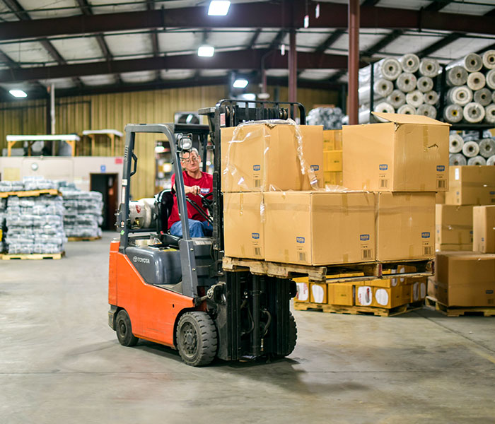 Forklift driver moving boxes